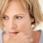 Pensive young woman, close-up, studio shot
